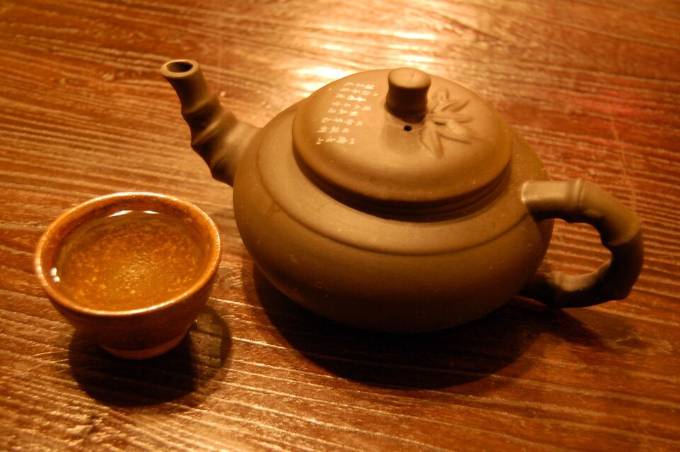 A cup of green tea and a teapot